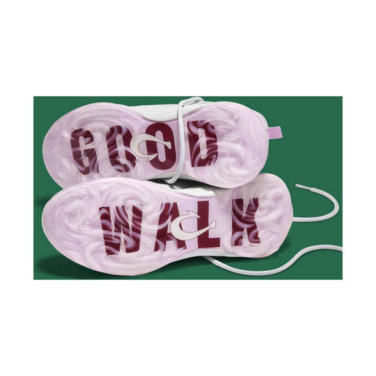 Pink golf shoe outsoles with swirling tread and large burgundy "GOLF" lettering