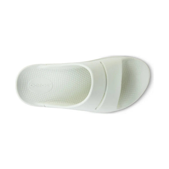 White slide sandal outsole with textured tread and embossed OOFOS logo