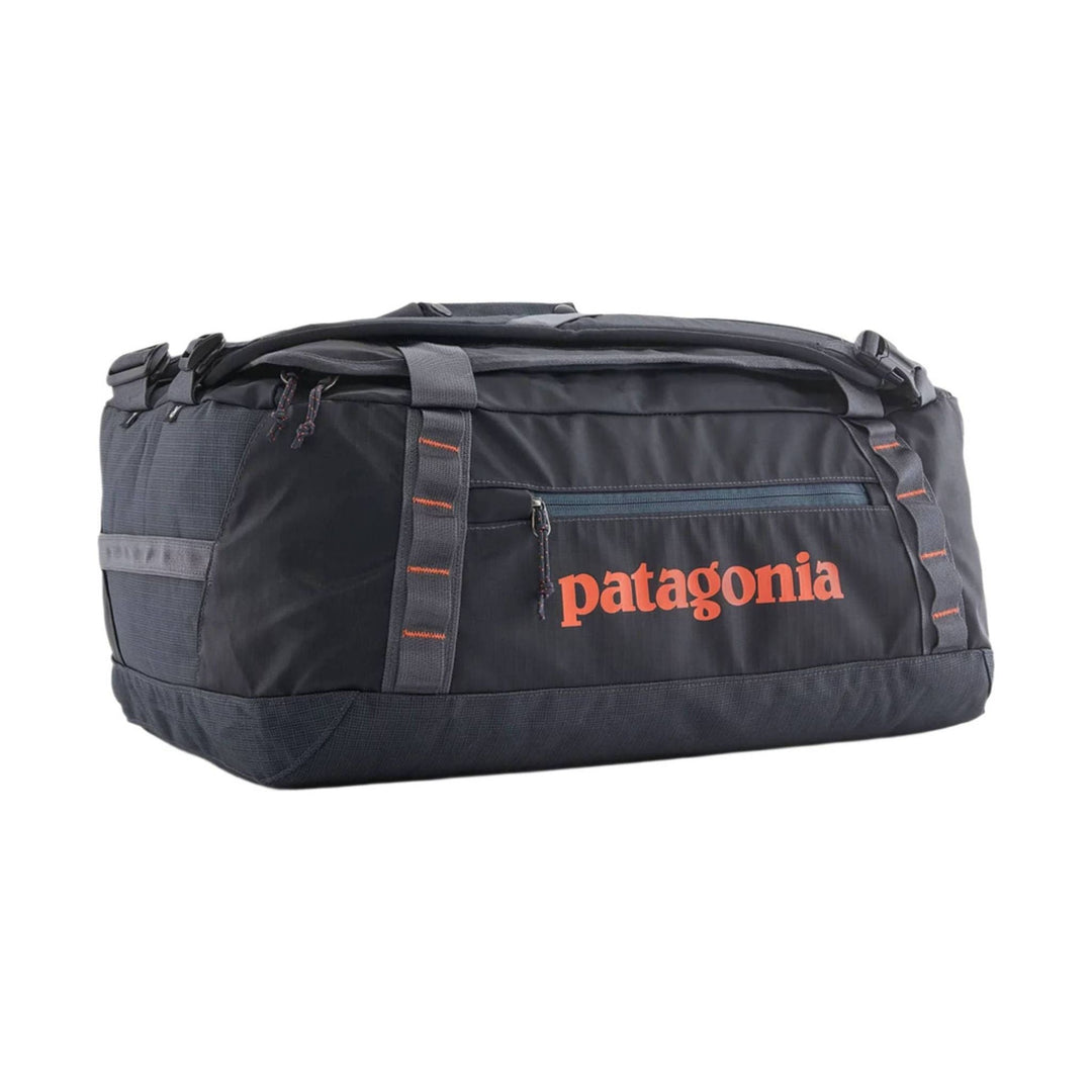 Black duffel bag with orange Patagonia logo and zipper pocket, shown in side view