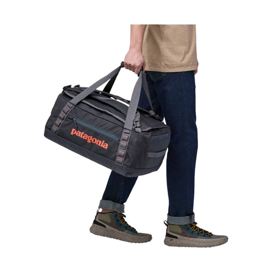 Black duffel bag with gray straps and orange Patagonia logo