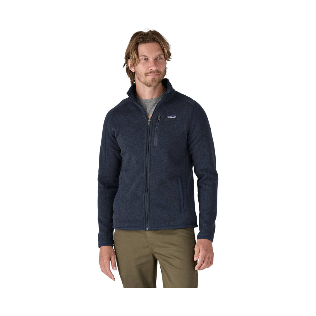 Navy zip-up fleece jacket with chest logo, worn over a gray shirt