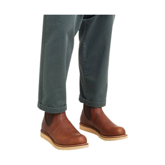 Brown Chelsea boots with tan soles, worn with cuffed gray pants