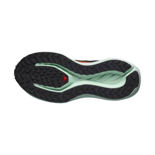 Trail running shoe outsole with black lugged rubber and a mint green midsole cutout