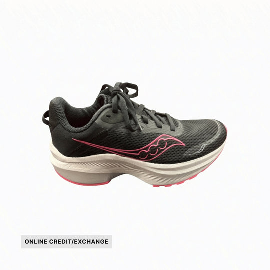 Black running shoe with pink side logo, white midsole, and online credit/exchange label