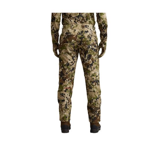 Camouflage hunting pants shown from the back, with fitted legs and brown boots visible at the hem