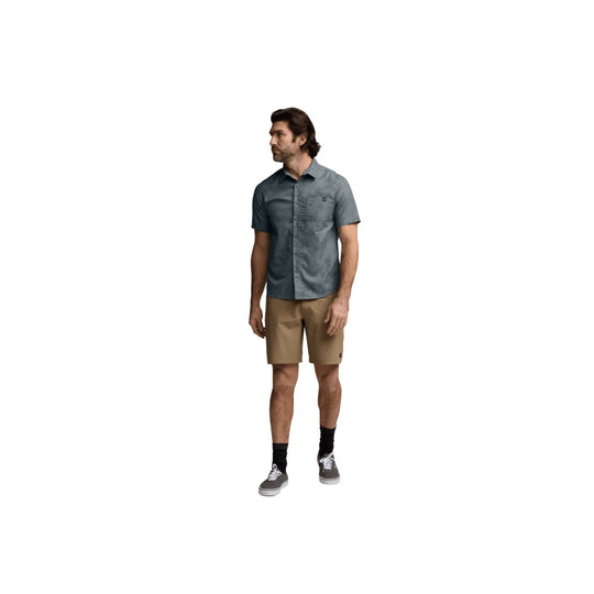 Men's short-sleeve button-up shirt in muted blue-gray with tan shorts, black socks, and gray sneakers
