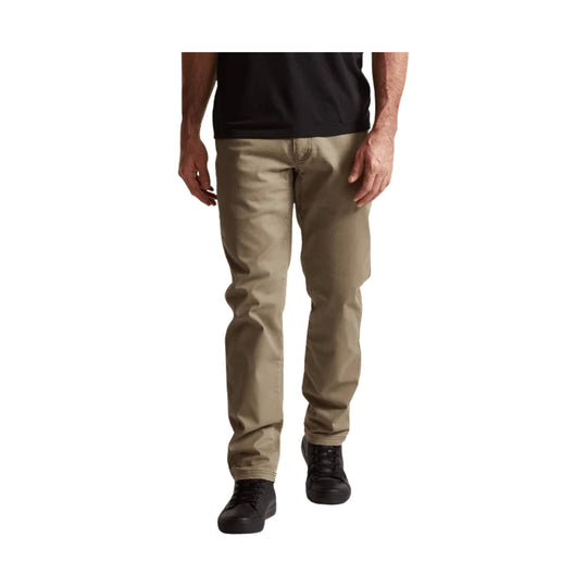 Khaki straight-leg pants worn with a black T-shirt and black sneakers