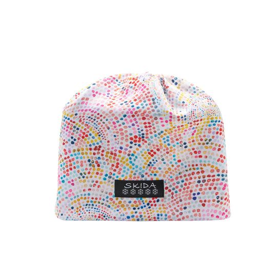 White knit beanie with multicolored dot pattern and a black SKIDA logo patch