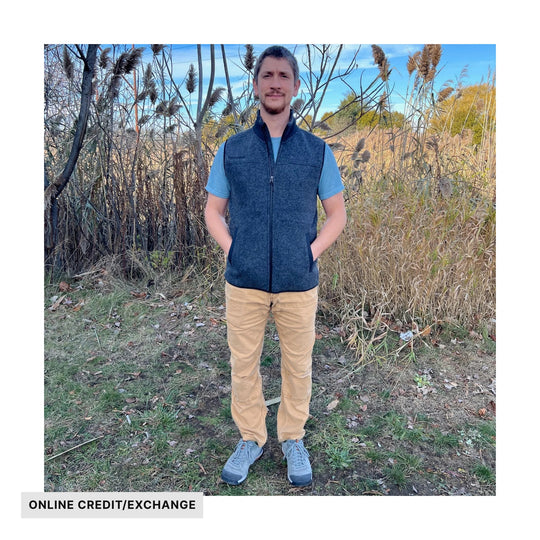 Charcoal zip-up fleece vest worn over a light blue T-shirt