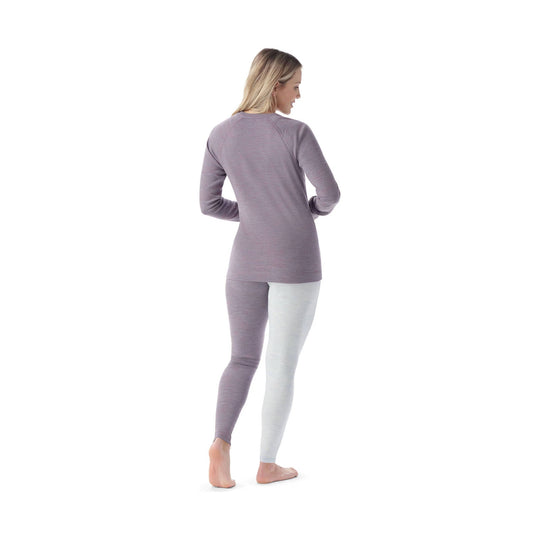 Woman modeling a long-sleeve crew neck base layer and leggings set in lavender and light gray, shown from the back
