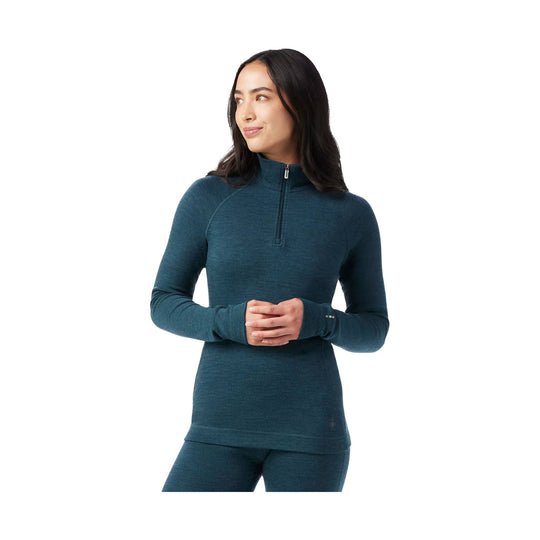 Woman wearing a teal long-sleeve quarter-zip base layer