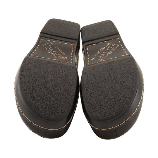 Pair of dark brown clogs shown from the sole side with treaded rubber bottoms and printed branding