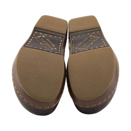 Brown lugged shoe outsoles with textured heel pads and printed branding