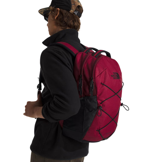 Red backpack with black trim, bungee cord front lacing, and top carry handles