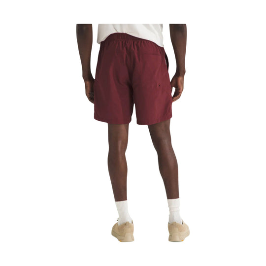 Maroon athletic shorts with elastic waistband and loose fit, shown on a model from the front