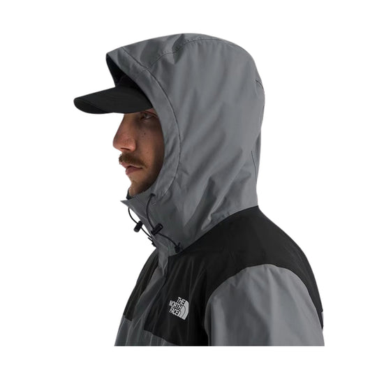Gray hooded jacket worn with a black cap, shown in side profile