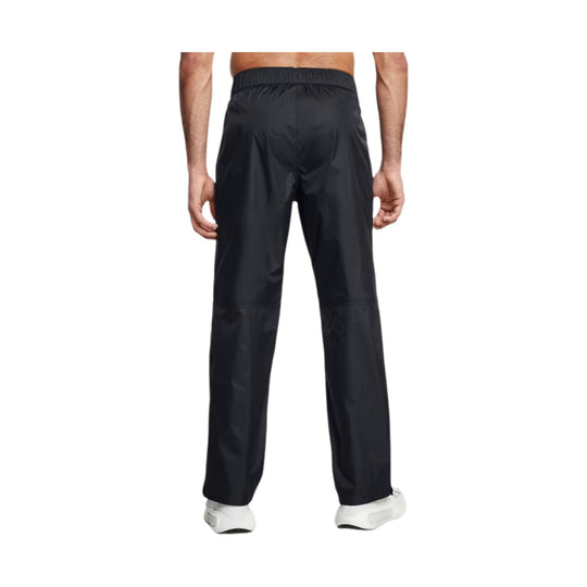 Black rain pants shown from the back with an elastic waistband and straight legs