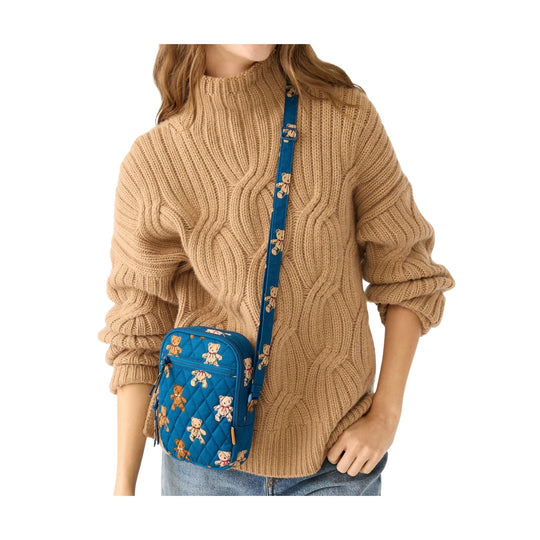 Tan cable-knit sweater with a blue crossbody bag featuring teddy bear prints