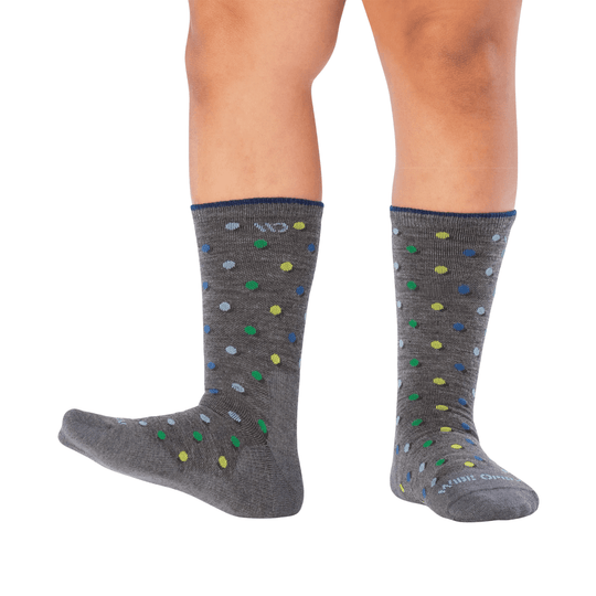 Gray crew socks with multicolor polka dots, shown on legs against a white background.