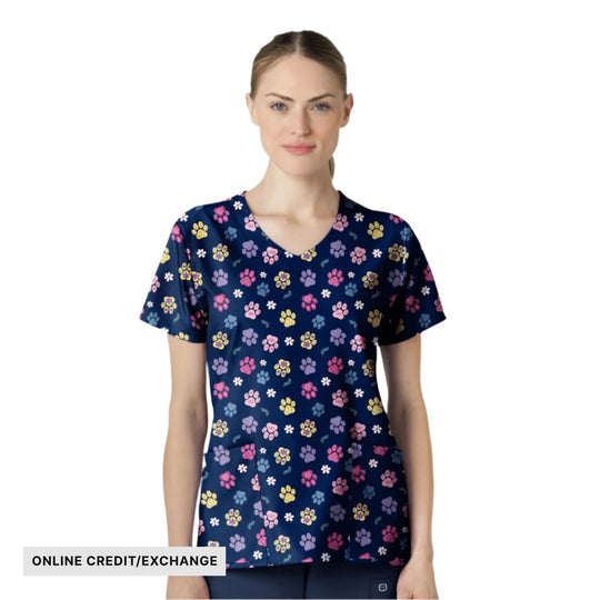 Navy V-neck scrub top with colorful paw print and flower pattern, shown on a model