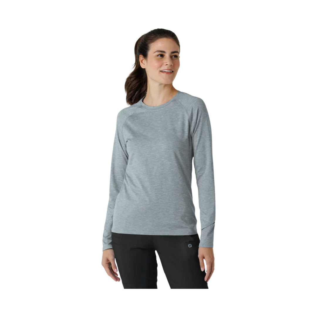 Gray long-sleeve athletic top with raglan sleeves, shown on a model