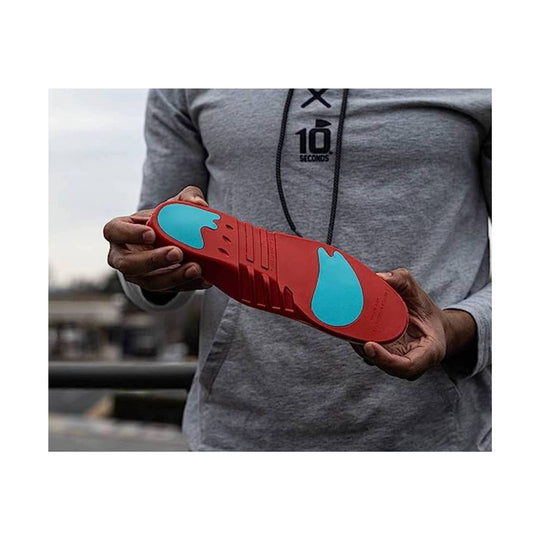 Red insole with blue cushioning pads held in both hands