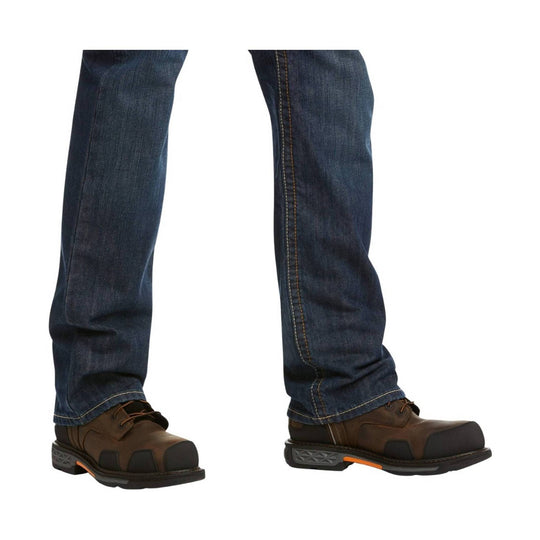 Dark wash boot-cut jeans worn with brown work boots, shown from the knees down