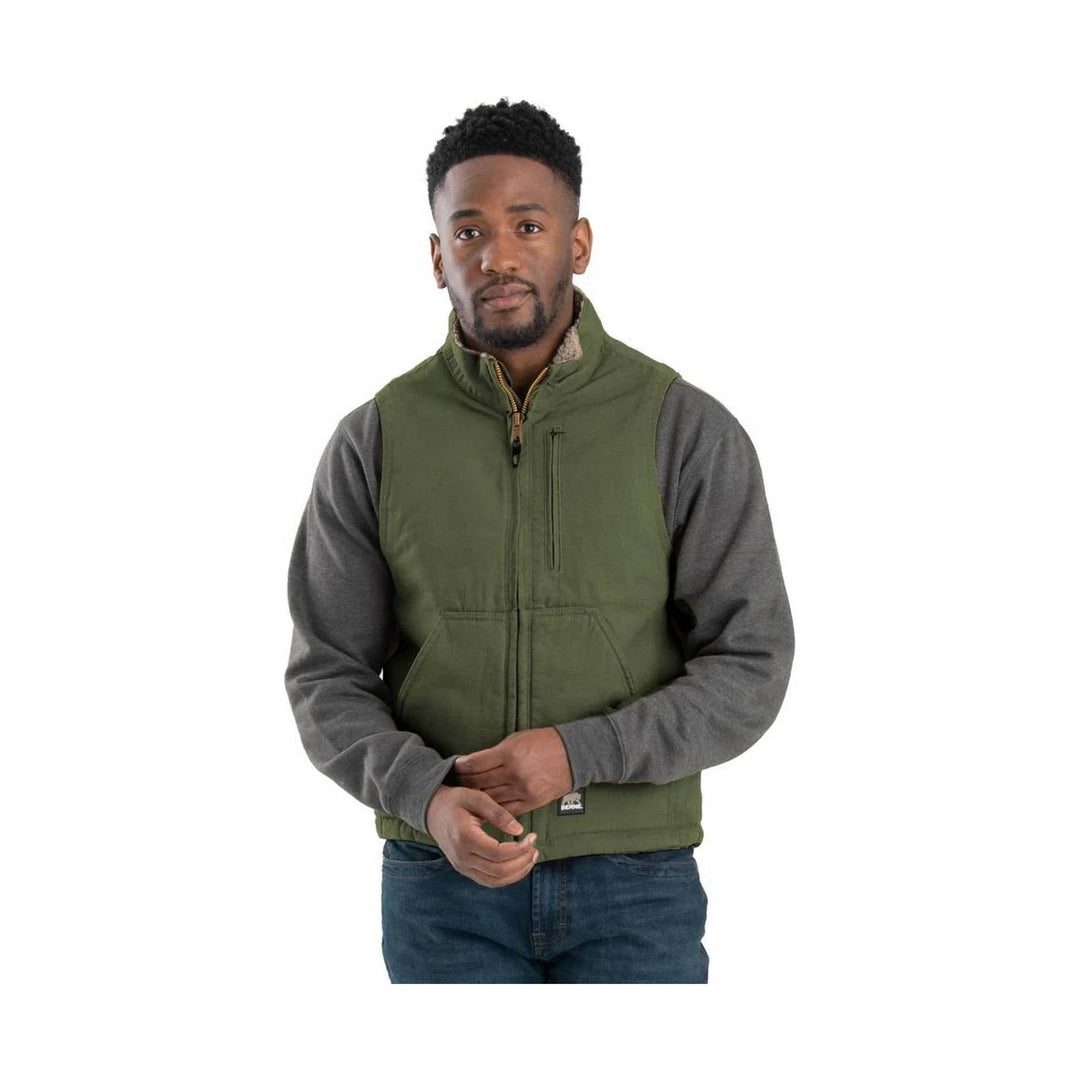 Olive green sherpa-lined vest over a gray long-sleeve shirt and jeans