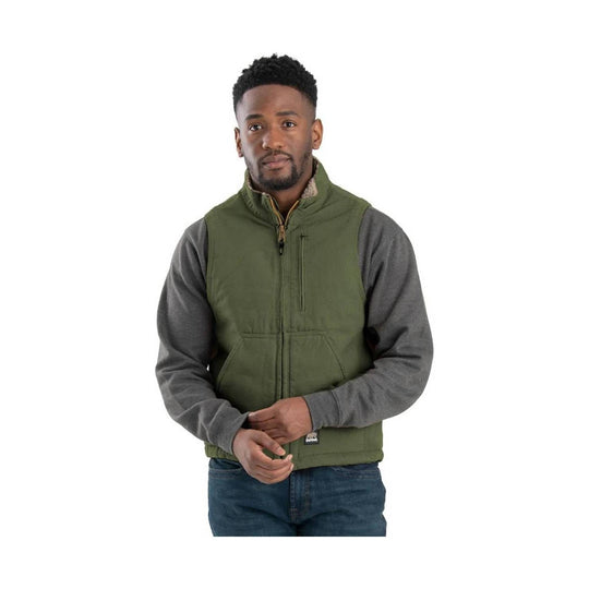 Olive green sherpa-lined vest over a gray long-sleeve shirt and jeans