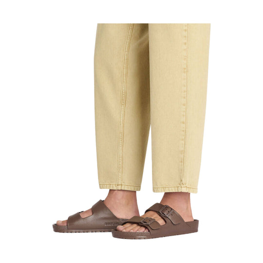 Brown two-strap slide sandal on a model wearing beige cropped pants