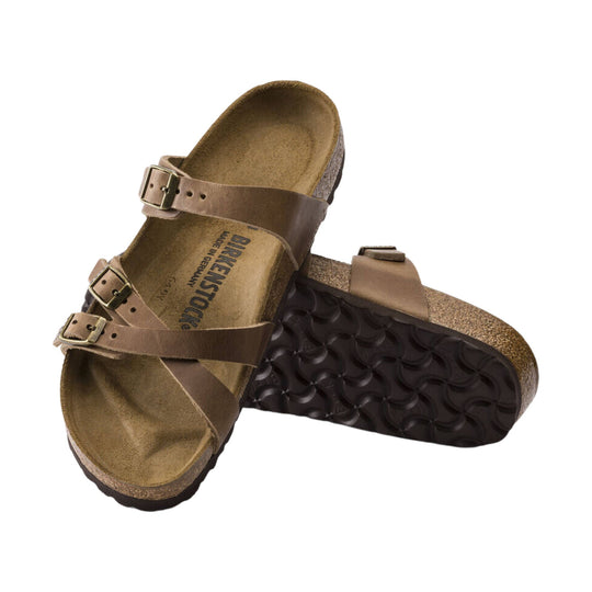 Brown two-strap cork footbed sandal with metal buckles, shown stacked on a white background