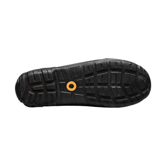 Black boot outsole with deep tread and an orange circular detail near the center