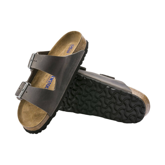 Brown two-strap cork footbed sandal with black sole and buckles, shown from the side and bottom