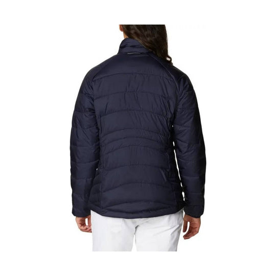 Navy quilted puffer jacket shown from the back on a model