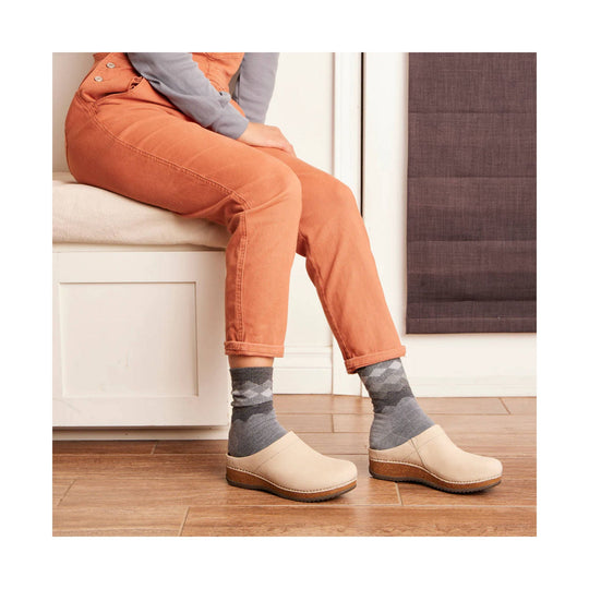 Beige closed-toe clog with a cork sole worn with gray patterned socks