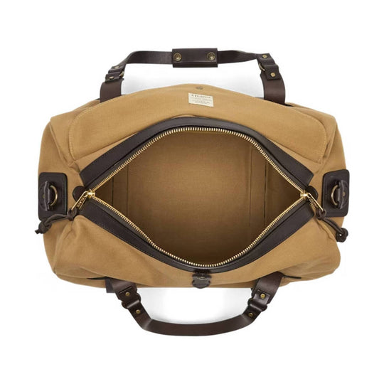 Tan canvas duffel bag with dark leather handles, gold-tone hardware, and an open top zipper