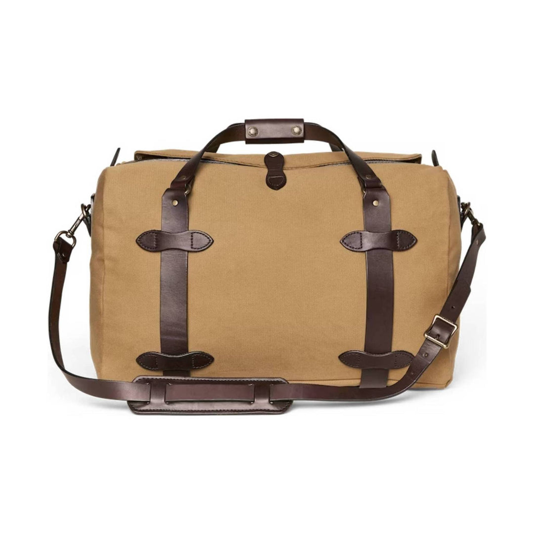 Tan canvas duffel bag with dark leather straps, top handles, and an adjustable shoulder strap