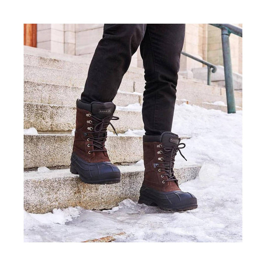 Brown lace-up winter boots with black rubber toe and sole on snowy steps