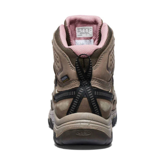 Tan and pink hiking boot seen from the back with black bungee laces and a thick treaded sole