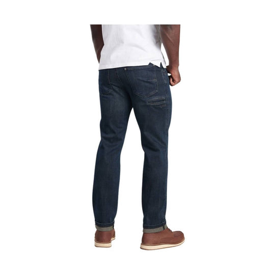 Dark wash slim-fit jeans shown from the back with cuffed hems and brown shoes