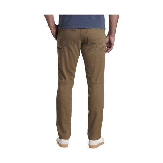 Man wearing slim khaki pants with tapered legs, back view