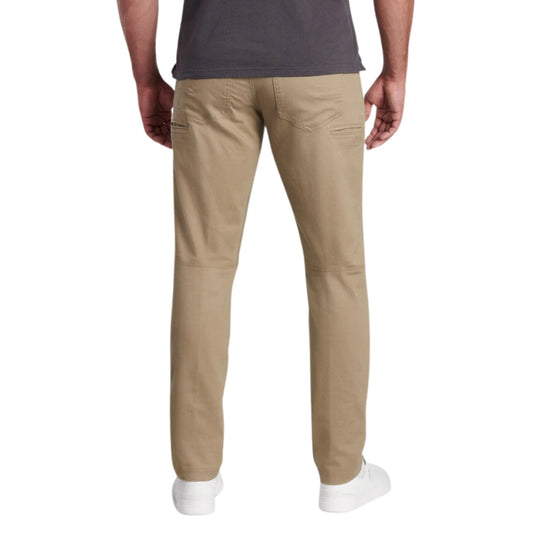 Tan tapered pants shown from the back with zip pockets and white sneakers visible