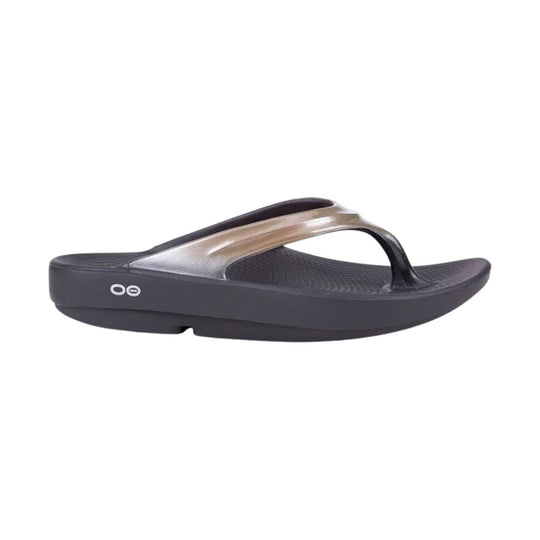 Black and tan platform flip-flop sandal with a sculpted sole and logo on the side