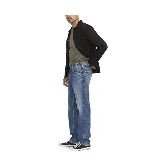 Blue straight-leg jeans with five-pocket styling, shown on a model with a black overshirt and sneakers.