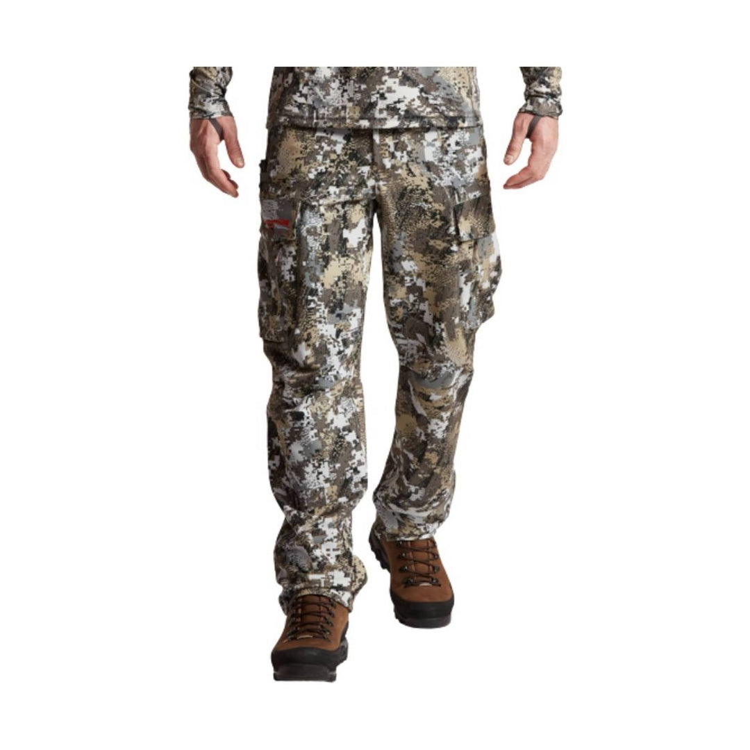 Camouflage cargo pants with articulated knees and brown hiking boots