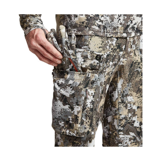Camo cargo pants with a hand pulling out a pocket knife