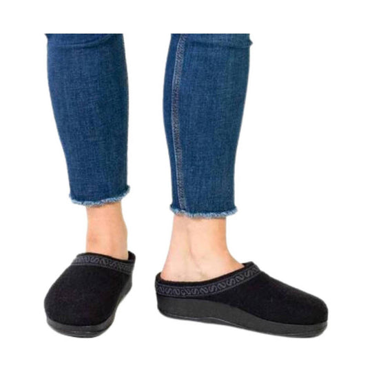 Black slip-on wool clogs with low black soles worn with cropped jeans