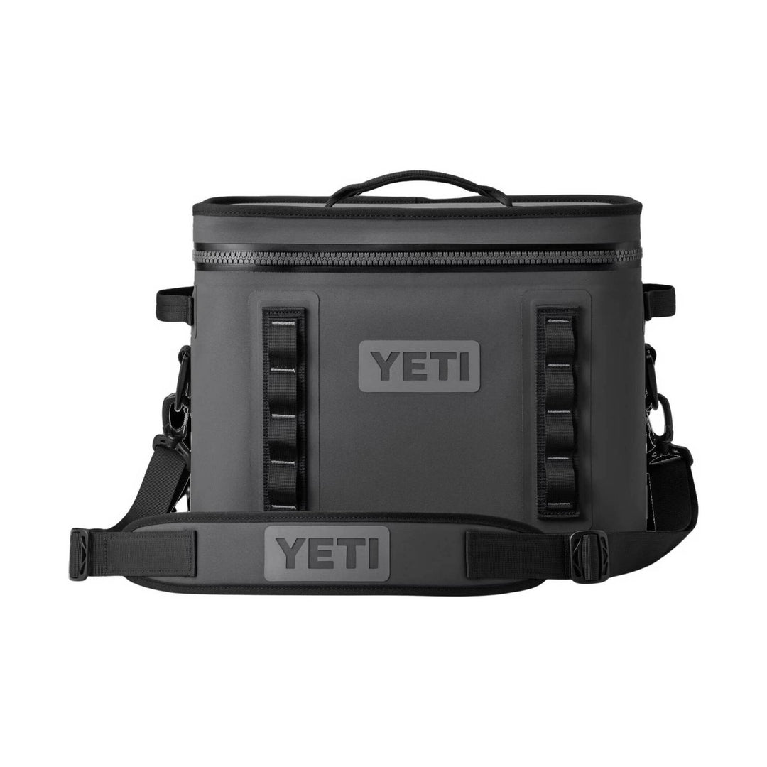 Dark gray soft cooler with front logo patch, top handle, and shoulder strap